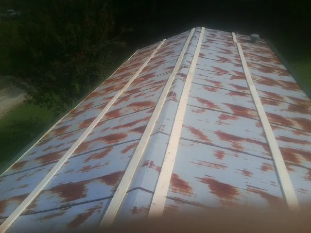 Rusted metal roof panels with new wood purlins before replacement — Storm Damage Roof Repair in Micro by Roofing Brothers