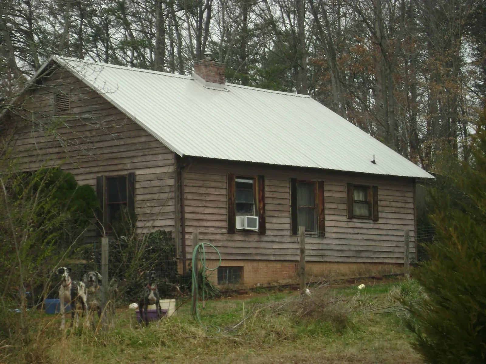 White metal roof on an old wood sided farmhouse, from a Metal Roof Installation job in Micro